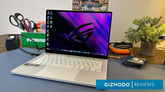 A ROG Zephyrus Laptop showing the main desktop screen next to several nicknacks and Pokemon cards.