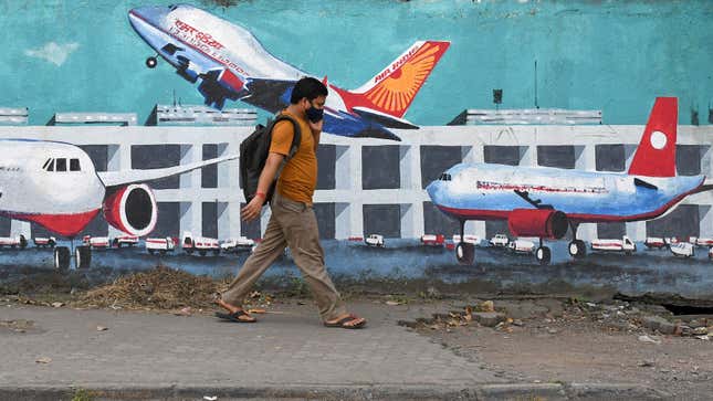 A man walks past a painting of an airport