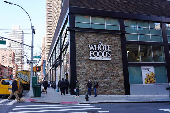 People are seen lined up in front of Whole Foods during the coronavirus pandemic 