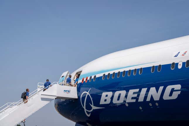Visitors climb steps to take a tour of a Boeing 777X jet airliner in Farnborough, England.