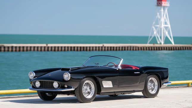 A black Ferrari convertible parked by the sea