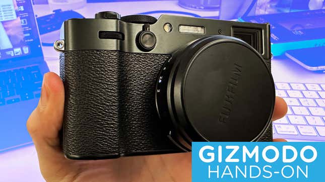 Fujifilm camera being held in front of a desk. 
